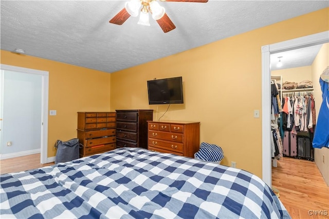 10327 Wolcott Hill Rd, Camden, NY 13316 - bedroom featuring wood finished floors, a spacious closet, a textured ceiling, a closet, and a ceiling fan