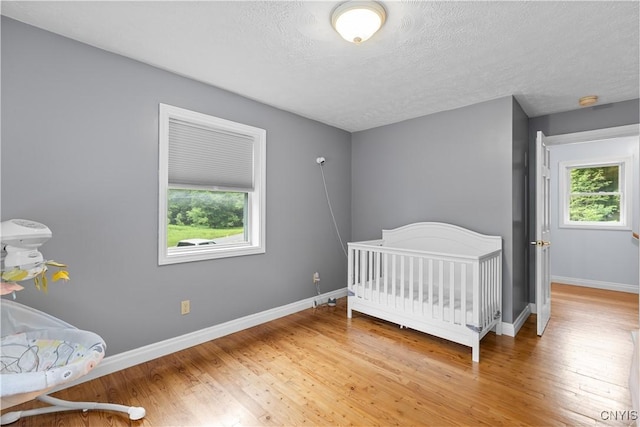 10327 Wolcott Hill Rd, Camden, NY 13316 - bedroom with multiple windows, light wood-style floors, and a textured ceiling