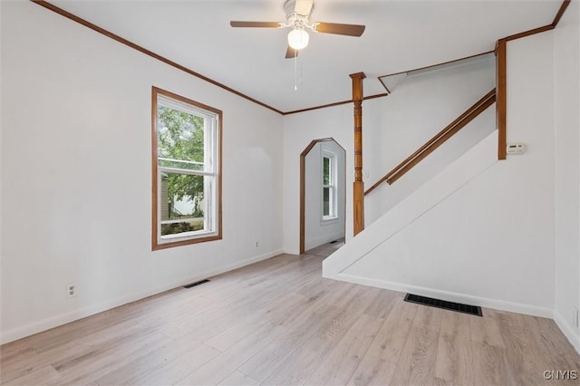 364 S 6th St, Fulton, NY 13069 - unfurnished living room featuring wood finished floors, stairs, ornamental molding, a ceiling fan, and arched walkways