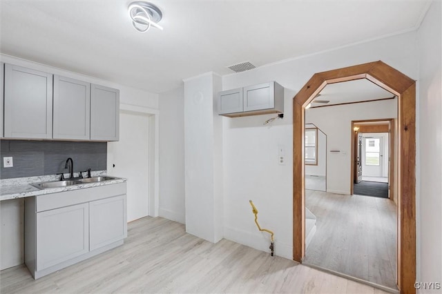 364 S 6th St, Fulton, NY 13069 - kitchen with light wood-type flooring, gray cabinetry, tasteful backsplash, and light stone countertops