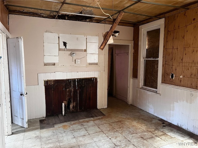 506 Glenwood Ave, Buffalo, NY 14208 - unfurnished living room with wooden walls, light flooring, and a wainscoted wall