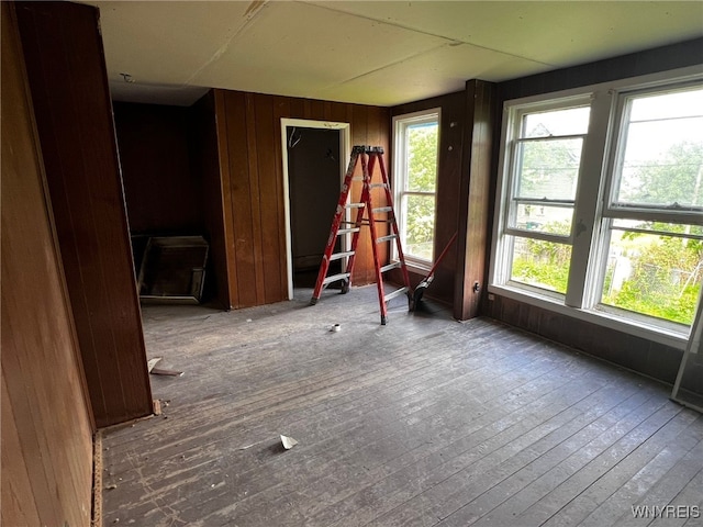 506 Glenwood Ave, Buffalo, NY 14208 - unfurnished room with plenty of natural light, wooden walls, and hardwood / wood-style floors