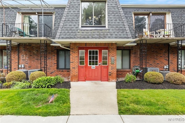 75B Foxberry Dr, Amherst, NY 14068 - property entrance with a balcony, brick siding, a shingled roof, and mansard roof