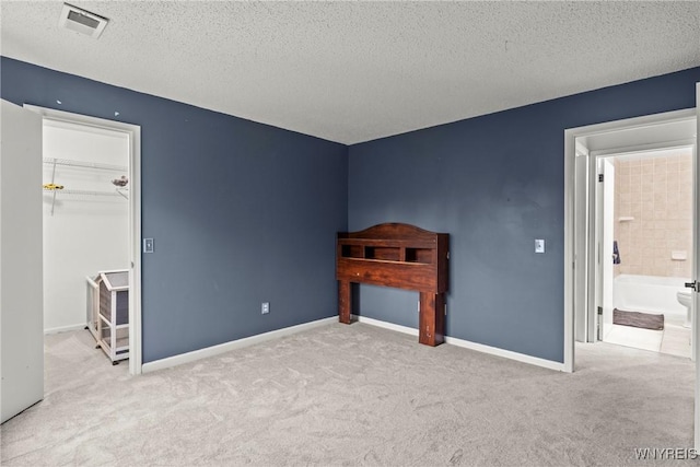 75B Foxberry Dr, Amherst, NY 14068 - unfurnished bedroom featuring a textured ceiling, a walk in closet, carpet, and a closet