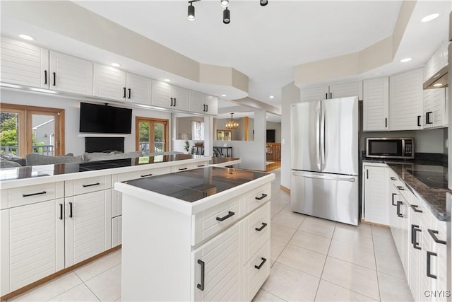 4925 Bentbrook Dr, Manlius, NY 13104 - kitchen with appliances with stainless steel finishes, light tile patterned floors, a kitchen island, a chandelier, and a fireplace