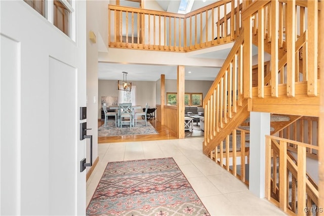 4925 Bentbrook Dr, Manlius, NY 13104 - entrance foyer with light tile patterned flooring, a towering ceiling, stairway, and a chandelier
