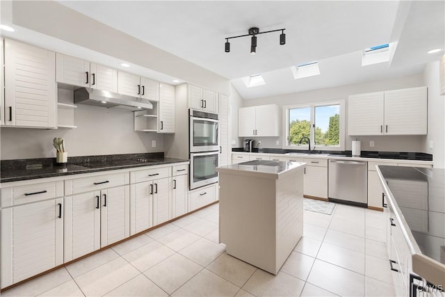 4925 Bentbrook Dr, Manlius, NY 13104 - kitchen with appliances with stainless steel finishes, under cabinet range hood, a skylight, a kitchen island, and recessed lighting