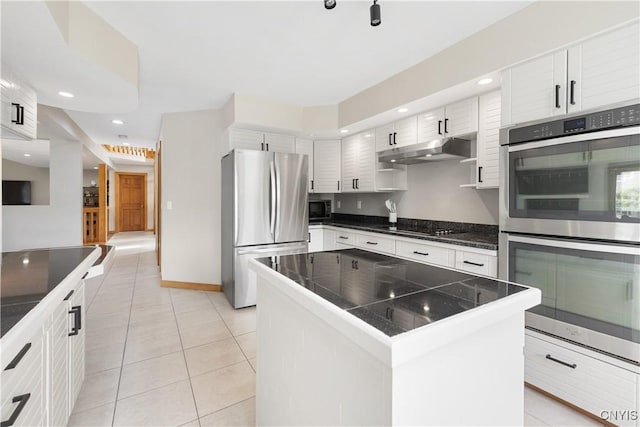 4925 Bentbrook Dr, Manlius, NY 13104 - kitchen featuring stainless steel appliances, under cabinet range hood, light tile patterned flooring, a kitchen island, and white cabinetry