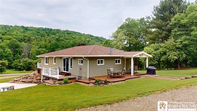 12483 Sawmill Run Rd, South Valley, NY 14738 - rear view of house with a lawn, a wooded view, and covered porch