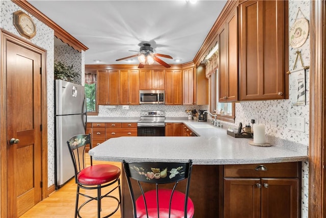 5107 County Road 36, Richmond, NY 14471 - kitchen featuring stainless steel appliances, light countertops, a peninsula, brown cabinets, and light wood-style flooring