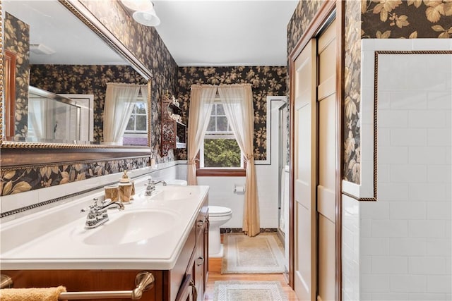 5107 County Road 36, Richmond, NY 14471 - bathroom featuring wallpapered walls, a shower stall, double vanity, and wood finished floors