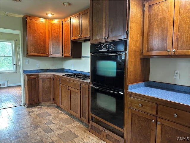 8362 Price Rd, Floyd, NY 13354 - kitchen with stainless steel gas stovetop, dark countertops, and brown cabinets