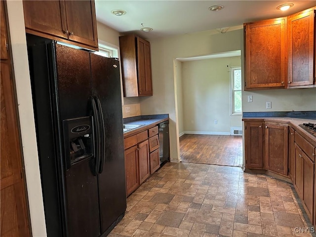 8362 Price Rd, Floyd, NY 13354 - kitchen with black fridge with ice dispenser, healthy amount of natural light, dishwashing machine, brown cabinetry, and recessed lighting