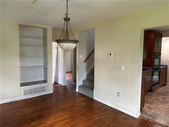 8362 Price Rd, Floyd, NY 13354 - unfurnished room featuring stairway, dark wood-type flooring, and built in shelves