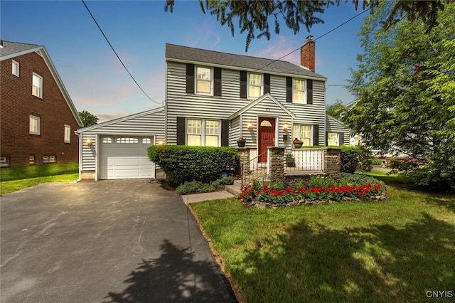 312 S Orchard Rd, Geddes, NY 13219 - colonial inspired home featuring a chimney, driveway, an attached garage, and a front lawn