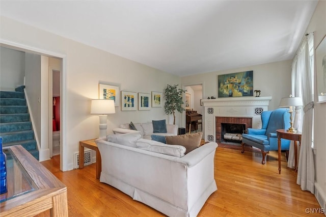 312 S Orchard Rd, Geddes, NY 13219 - living room with stairway, light wood-style flooring, and a fireplace