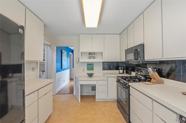 312 S Orchard Rd, Geddes, NY 13219 - kitchen with black appliances, open shelves, light countertops, and white cabinetry