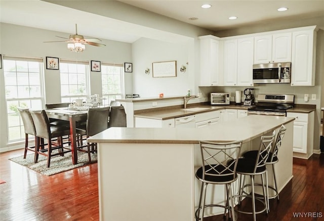 107 Naymik Dr, Sullivan, NY 13037 - kitchen with stainless steel appliances, a ceiling fan, dark wood finished floors, recessed lighting, and white cabinetry