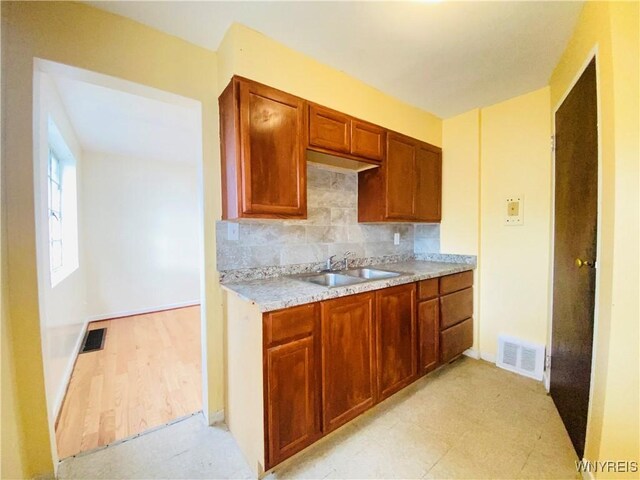 23 Bennett Village Ter, Buffalo, NY 14214 - kitchen with light countertops, backsplash, light floors, and brown cabinets