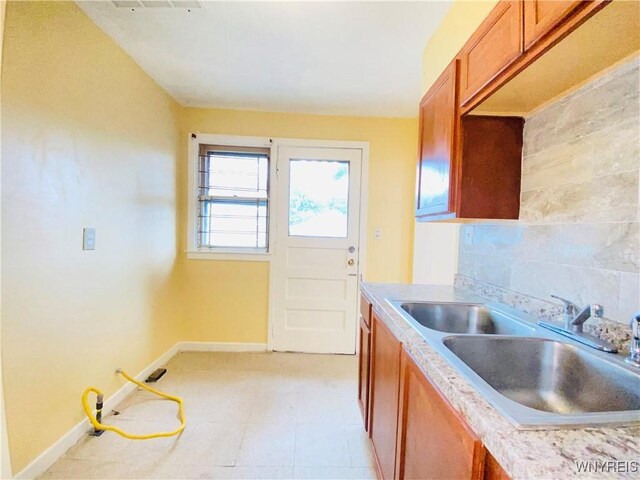 23 Bennett Village Ter, Buffalo, NY 14214 - kitchen featuring brown cabinetry, backsplash, and light countertops