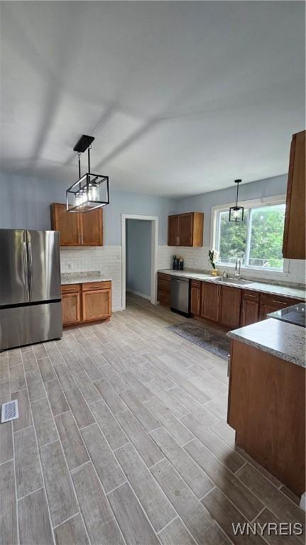 726 S Main St, Shelby, NY 14103 - kitchen featuring stainless steel appliances, light wood-type flooring, decorative backsplash, and pendant lighting