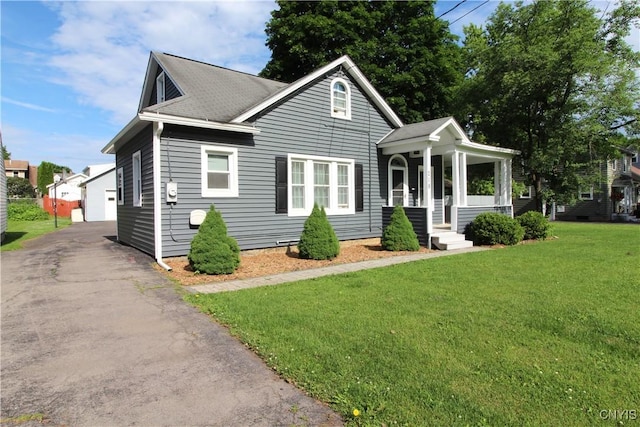 218 S Terry Rd, Geddes, NY 13219 - bungalow-style home featuring a front yard, an outbuilding, a detached garage, and roof with shingles
