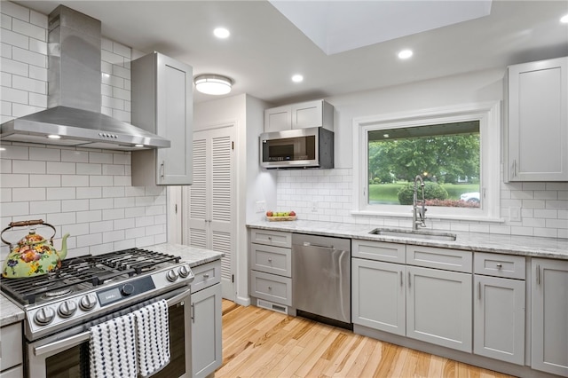 100 Carverdale Dr, Brighton, NY 14618 - kitchen with appliances with stainless steel finishes, wall chimney exhaust hood, decorative backsplash, light wood-style floors, and recessed lighting