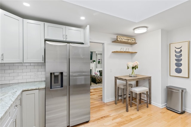 100 Carverdale Dr, Brighton, NY 14618 - kitchen with stainless steel fridge with ice dispenser, light wood-style floors, light stone countertops, tasteful backsplash, and recessed lighting