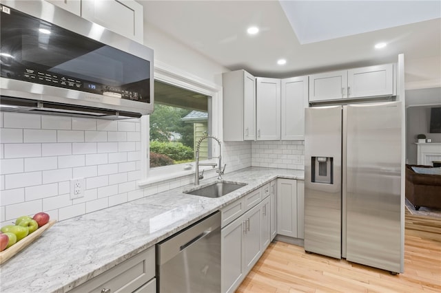 100 Carverdale Dr, Brighton, NY 14618 - kitchen with appliances with stainless steel finishes, light wood finished floors, light stone counters, tasteful backsplash, and recessed lighting