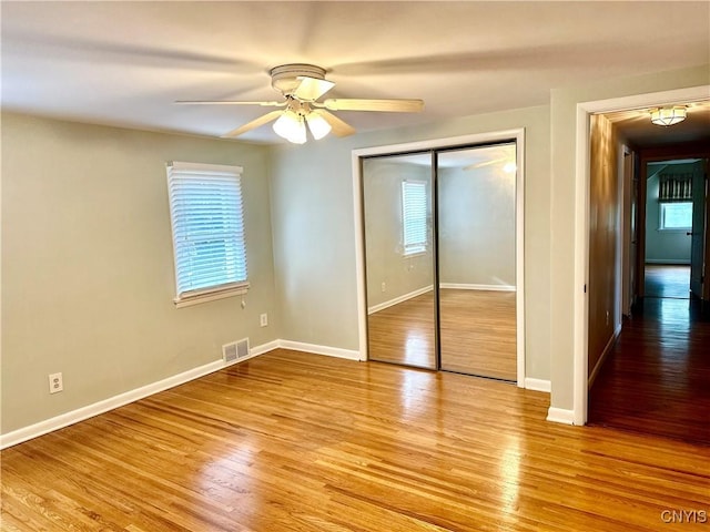 1000 Sherman Dr, Utica, NY 13501 - unfurnished bedroom with multiple windows, light wood-type flooring, and a closet