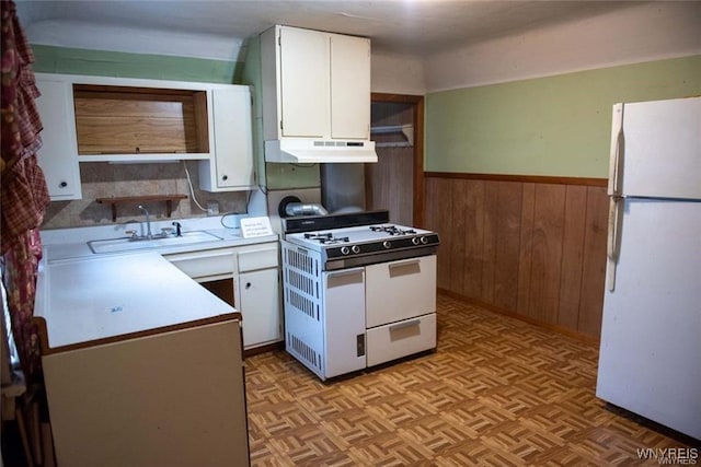 150 Weiss St, Buffalo, NY 14206 - kitchen featuring white appliances, under cabinet range hood, white cabinetry, wood walls, and wainscoting