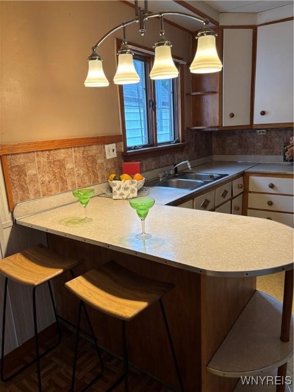 150 Weiss St, Buffalo, NY 14206 - kitchen featuring backsplash, a peninsula, a kitchen bar, and light countertops