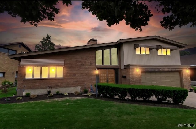 2503 Parkview Dr, Niagara Falls, NY 14305 - view of front of property with brick siding, an attached garage, a chimney, driveway, and a yard