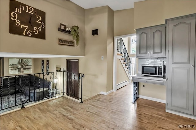 2503 Parkview Dr, Niagara Falls, NY 14305 - foyer with a baseboard heating unit, stairs, and wood finished floors