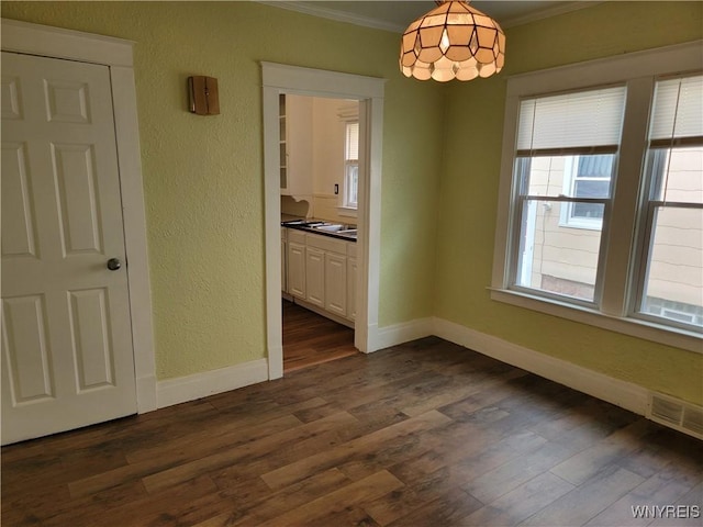 2255 Ontario Ave, Niagara Falls, NY 14305 - unfurnished dining area with ornamental molding, a textured wall, and dark wood-style floors
