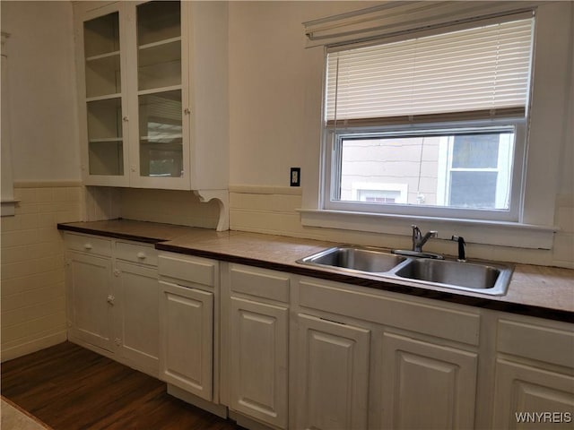 2255 Ontario Ave, Niagara Falls, NY 14305 - kitchen with glass insert cabinets, a wainscoted wall, dark wood-style flooring, white cabinetry, and tile walls