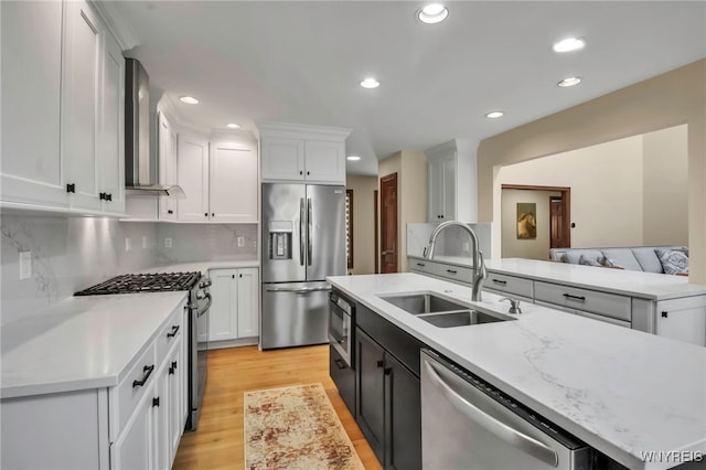 6290 Emily Ct, Clarence, NY 14032 - kitchen featuring appliances with stainless steel finishes, wall chimney exhaust hood, light wood-style flooring, white cabinetry, and recessed lighting