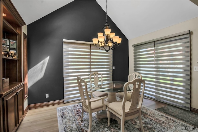 6290 Emily Ct, Clarence, NY 14032 - dining area featuring a chandelier, vaulted ceiling, and light wood-style flooring