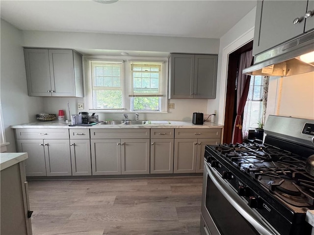 714 Arnett Blvd, Rochester, NY 14619 - kitchen with gas stove, gray cabinets, light countertops, light wood finished floors, and under cabinet range hood