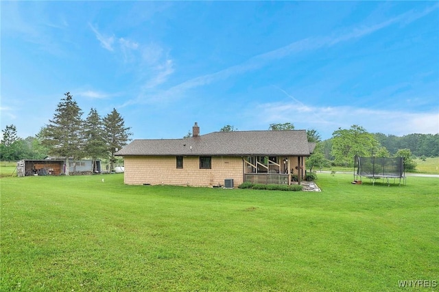 6557 Boberg Rd, Ashford, NY 14171 - back of house with a trampoline, a yard, a chimney, and a shingled roof