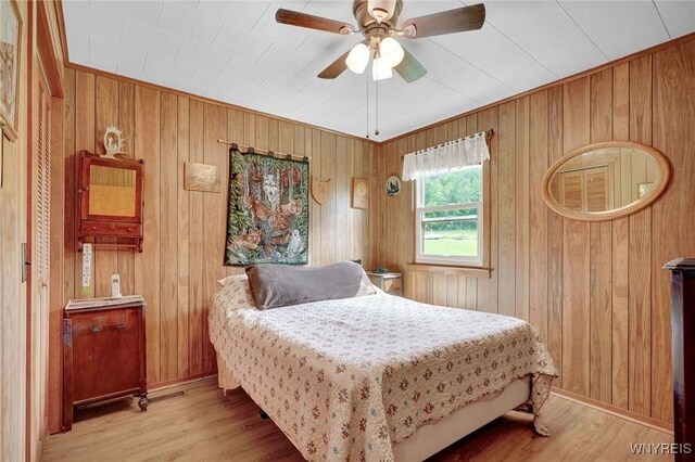 6557 Boberg Rd, Ashford, NY 14171 - bedroom with wood walls, wood finished floors, and a ceiling fan