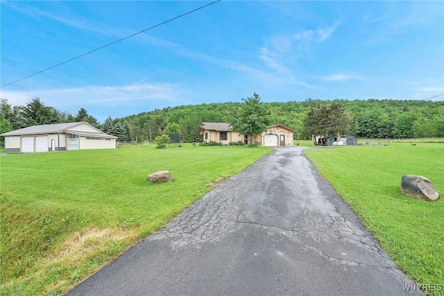 6557 Boberg Rd, Ashford, NY 14171 - ranch-style house featuring a garage, an outdoor structure, a forest view, and a front yard