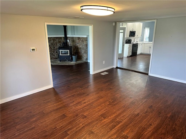 14918 Lakeshore Rd, Carlton, NY 14477 - spare room featuring a wood stove and dark wood-style floors
