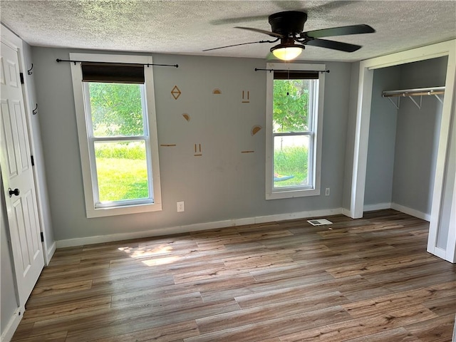 14918 Lakeshore Rd, Carlton, NY 14477 - unfurnished bedroom featuring wood finished floors, a textured ceiling, a closet, and a ceiling fan