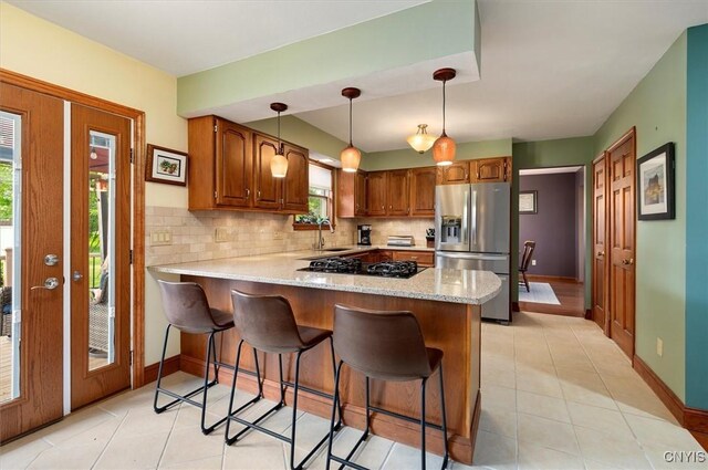 109 Hunt Valley Rd, Oneida-Inside, NY 13421 - kitchen with stainless steel fridge with ice dispenser, black gas stovetop, a peninsula, decorative backsplash, and brown cabinets