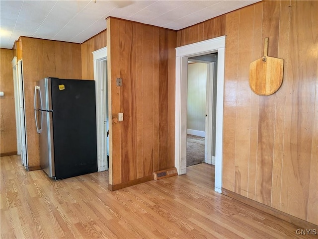 305 S Midler Ave, Syracuse, NY 13206 - kitchen with freestanding refrigerator, light wood-style flooring, wooden walls, and brown cabinets