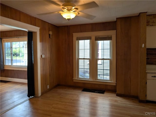305 S Midler Ave, Syracuse, NY 13206 - unfurnished dining area with light wood-style flooring, ceiling fan, and wood walls