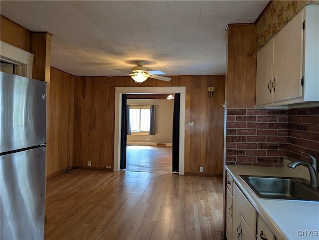 305 S Midler Ave, Syracuse, NY 13206 - kitchen with freestanding refrigerator, a ceiling fan, wooden walls, light wood-type flooring, and light countertops