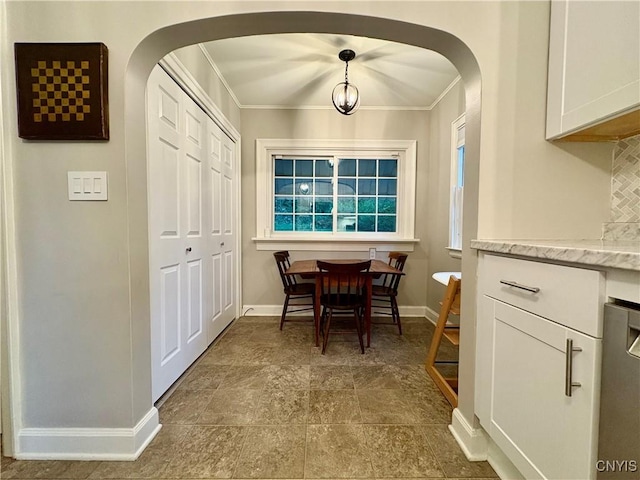 308 Haddonfield Dr, Dewitt, NY 13214 - dining area featuring arched walkways, crown molding, and dark stone finish flooring