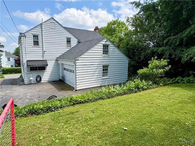 308 Haddonfield Dr, Dewitt, NY 13214 - view of home's exterior with driveway, a lawn, a garage, a shingled roof, and a chimney